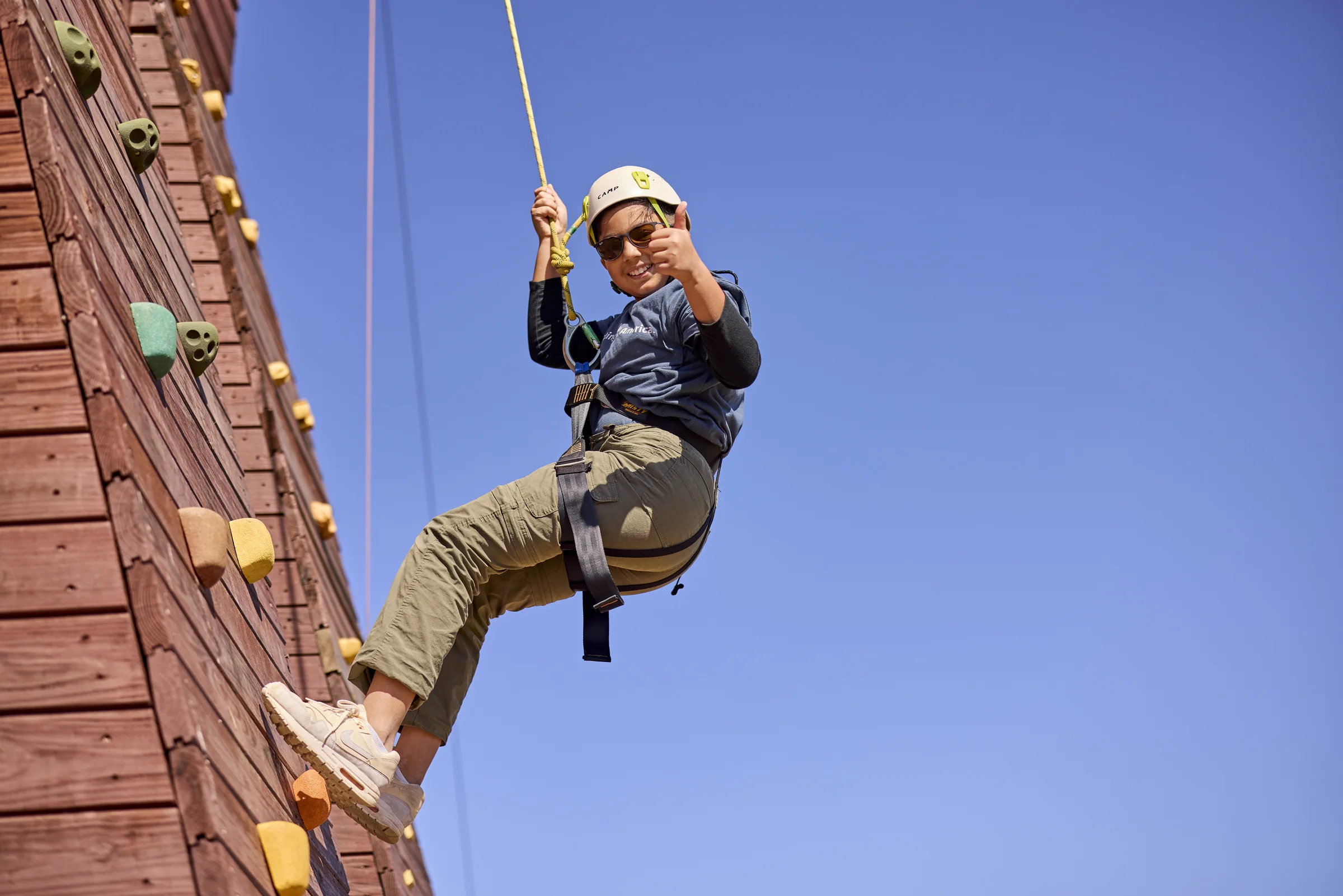A Scout rappelling at an outdoor climbing activity